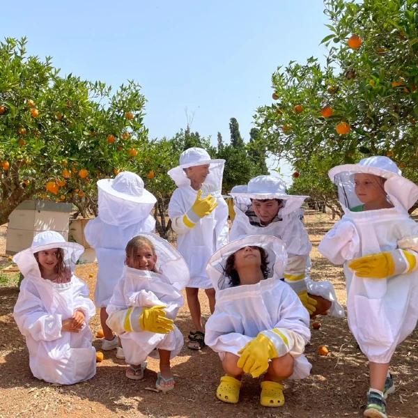 Picture of Kids learning about bees and honey dressed up with safe suits